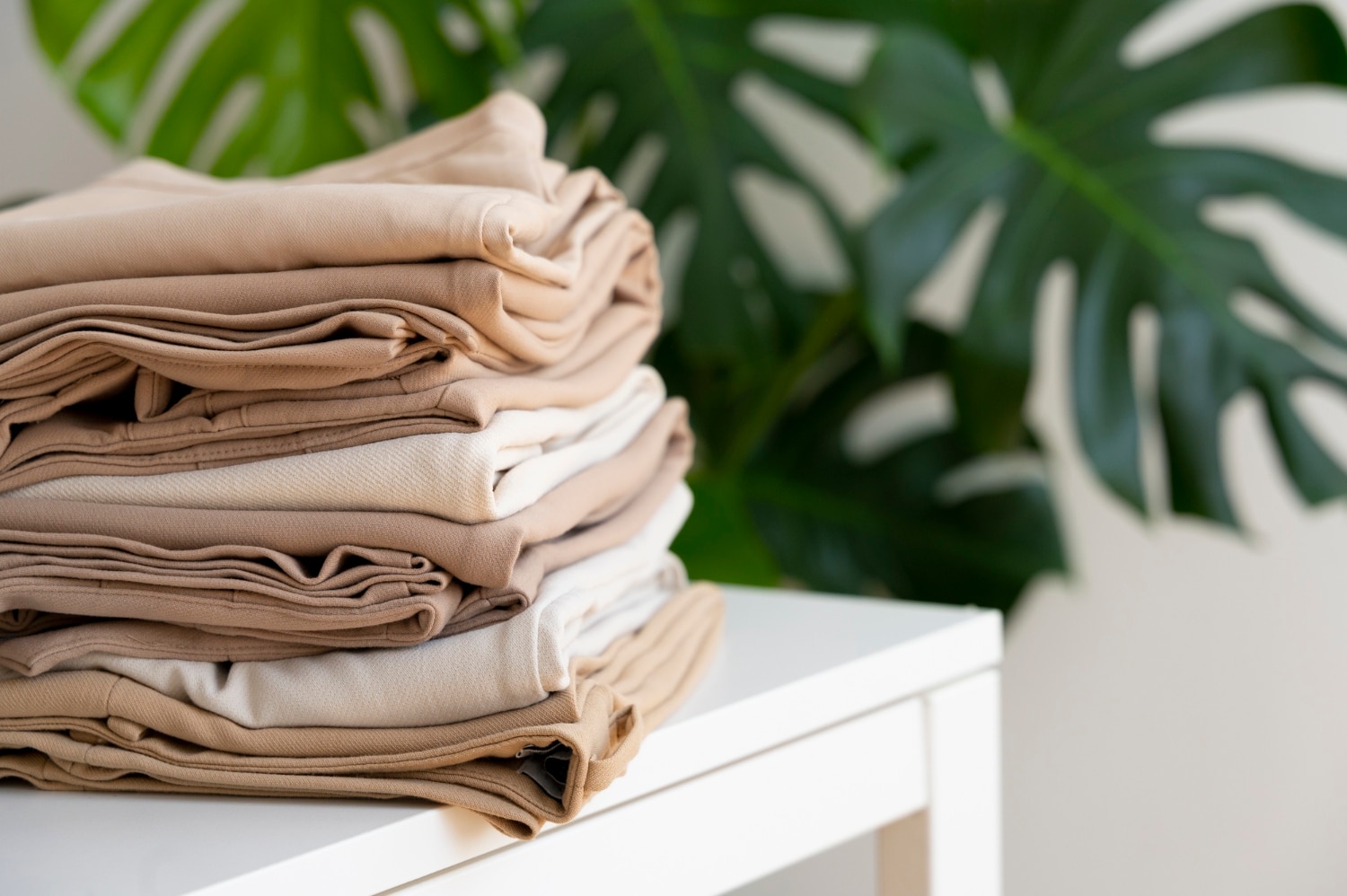Du linge de maison disposé en tas de couleur beige et blanc