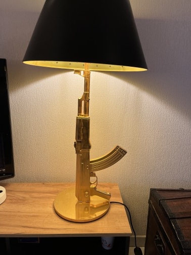Lampe design Gun Lampe Gun, designer Philippe Starck pour FLOS en 2005. 
Le pied représente un fusil d'assaut AK 47